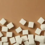Kiub gula putih bertaburan di atas permukaan coklat muda dilihat dari atas