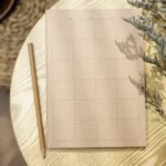 Kalendar bulanan kosong dan pensel di atas meja kayu