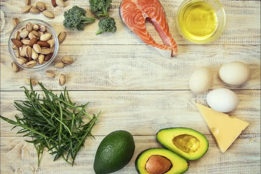 Salmon, telur, keju, kacang dan avokado di atas meja kayu